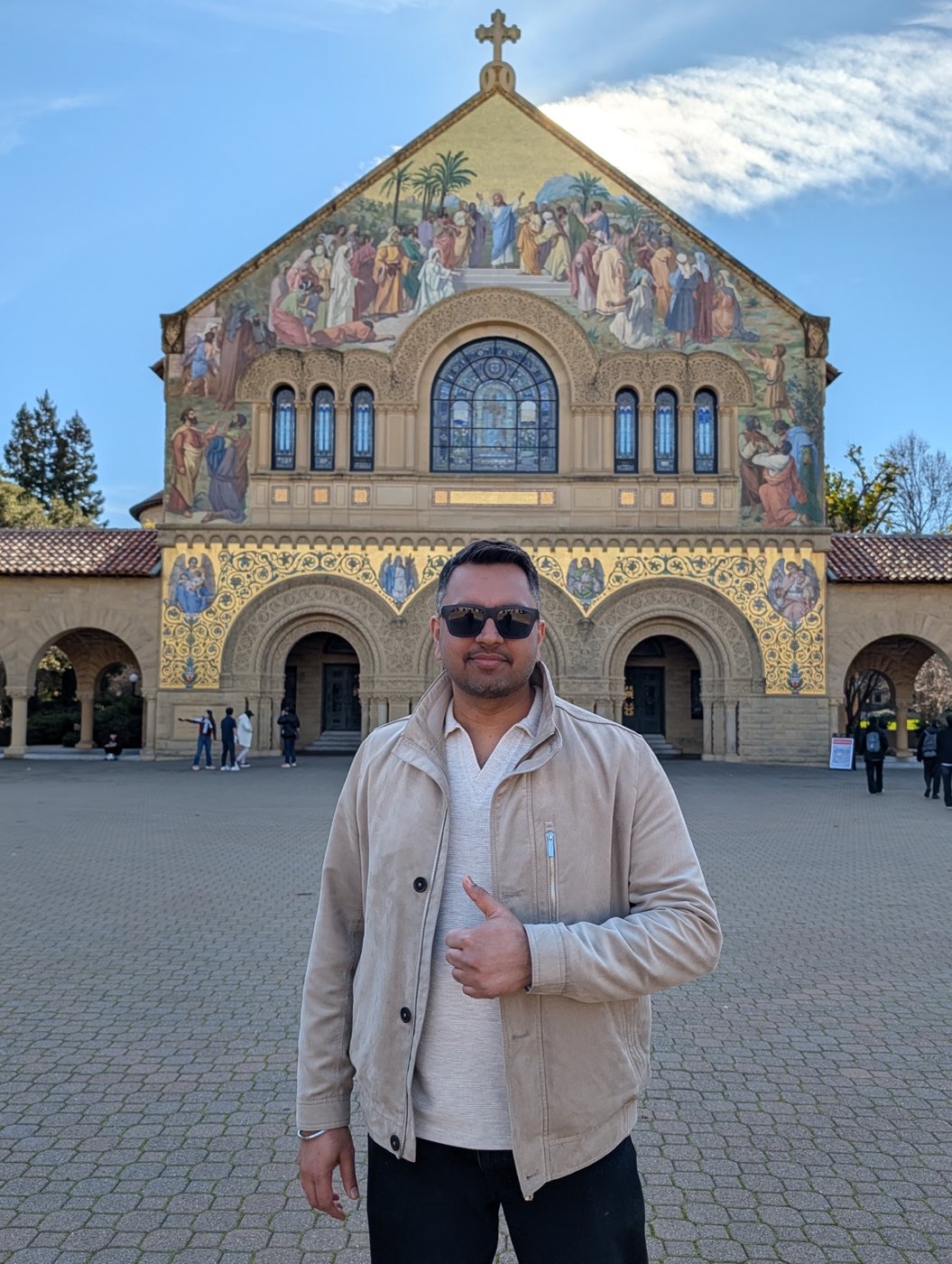 Aman outside an ornate building during his travels